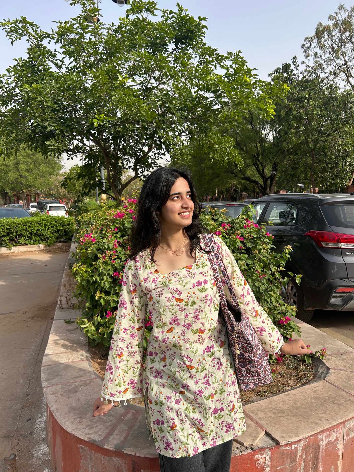 Woman wearing whimsical floral print cotton kurti with square neck and full sleeves