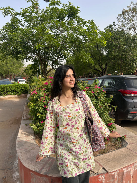 Woman wearing whimsical floral print cotton kurti with square neck and full sleeves